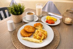 a table with two plates of breakfast food and a cup of coffee at Delfin Hotel Collection Rodadero in Rodadero