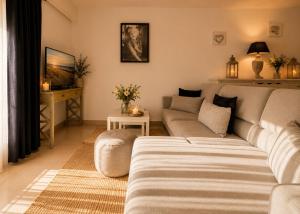 a living room with a couch and a tv at Le Aix Rotonde Mirabeau - Centre Ville Terrasse Garage in Aix-en-Provence