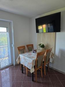 a dining room with a table with chairs and a television at Mandala Terra in Gračišče