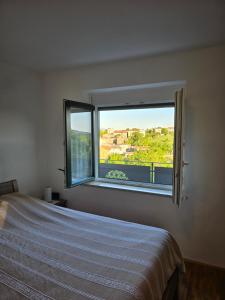 a bedroom with a bed and a window with a view at Mandala Terra in Gračišče
