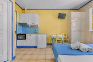 a room with a bed and a small kitchen at Aiolos Rooms in Tsoukalades