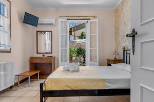 a bedroom with a bed and an open door at Aiolos Rooms in Tsoukalades