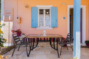 a table and chairs on a patio with a window at Aiolos Rooms in Tsoukalades +57 photos