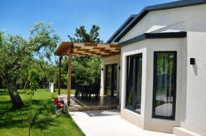 a wooden pergola over a patio of a house at Aivazidis Residence I in Skala Kallirachis +25 photos