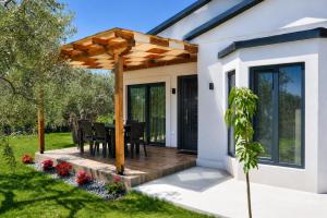 a patio with a table and a wooden pergola at Aivazidis Residence I in Skala Kallirachis