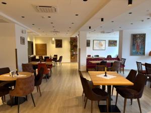 a dining room with wooden tables and chairs at Konak Studenica 1186 in Kraljevo