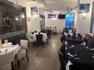 ein Restaurant-Speisesaal mit Tischen und Stühlen mit Tischplatte in der Unterkunft Bennetts Hotel in Long Eaton