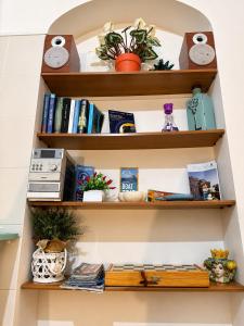 a shelf with books and other items on it at B&B A Vinedda in Scilla