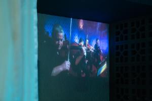a large screen with a picture of a group of musicians at The Beach House Estadias in Itapoa