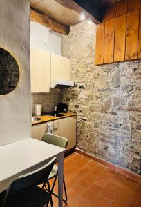 a kitchen with a table and chairs and a brick wall at Dolce Notte - Rustico a Gandria in Lugano