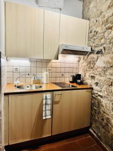 a kitchen with wooden cabinets and a sink at Dolce Notte - Rustico a Gandria in Lugano +12 photos
