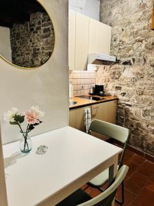 a kitchen with a table with a vase of flowers on it at Dolce Notte - Rustico a Gandria in Lugano