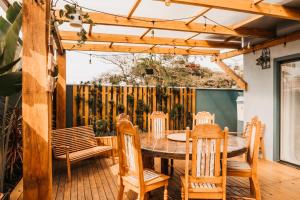 a dining room with a table and chairs on a wooden deck at The Beach House Estadias in Itapoa