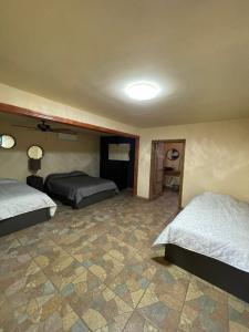 a bedroom with two beds and a tiled floor at Habitacion G in San Quintín