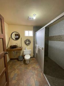 a bathroom with a toilet and a walk in shower at Habitacion G in San Quintín