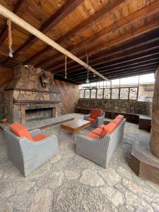 an outdoor patio with chairs and a stone fireplace at Habitacion G in San Quintín