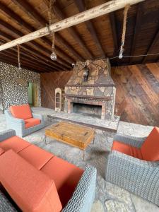 an outdoor living room with a stone fireplace at Habitacion G in San Quintín