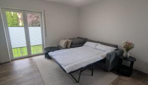a bed in a room with a couch and two tables at Ferienhaus freiZeit in Rudolstadt