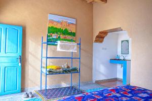 a room with a bed with a painting on the wall at Kasbah Abdou in El Kelaa des Mgouna