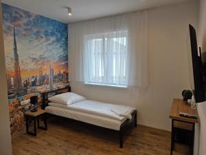 ein Schlafzimmer mit einem Bett und einem Gemälde einer Stadt in der Unterkunft VUELO - shuttle gratis in Pyrzowice