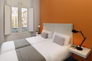 a hotel room with a bed and two lamps at Apartamentos Calle Larios in Málaga