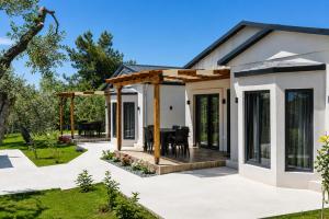 a home with a patio and a dining area at Aivazidis Residence II in Skala Kallirachis