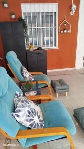 a living room with blue chairs and a couch at Apartamento Perea playa in Tavernes de Valldigna