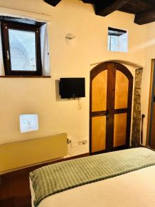 a bedroom with a bed and a door with a television at Dolce Notte - Rustico a Gandria in Lugano