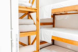 a room with bunk beds and towels at The Beach House Estadias in Itapoa +24 photos