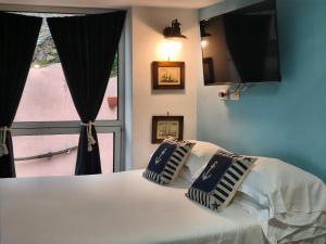 a bedroom with a bed with two pillows and a window at Casetta Mami in Camogli
