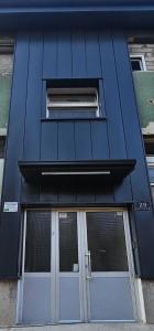 a blue building with two doors and a window at Apartman Hendek Tuzla in Tuzla