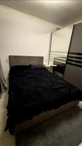 a bed with a black comforter in a bedroom at Dory Studio in Drobeta-Turnu Severin