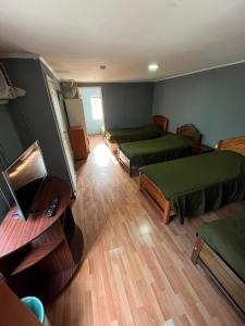 a room with two beds and a desk with a laptop at Hostal JV CASA AMPLIA in Nogales