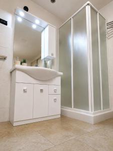 a white bathroom with a sink and a shower at La Tavernetta in Casto +8 photos