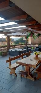 a wooden table and bench under an umbrella on a patio at La Terrazza Casa Vacanza in Carenno