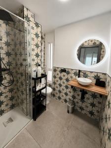 a bathroom with a toilet and a sink and a mirror at Penthouse San Isidro 3 suites Terraza Privada Parking in Granada +40 photos