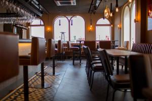 a dining room with tables and chairs and windows at The Pier Hotel in Harwich