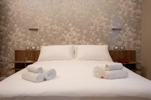 a bedroom with a white bed with towels on it at L'Alòz in Lugo