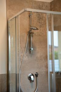 a shower with a glass door with a shower head at L'Alòz in Lugo