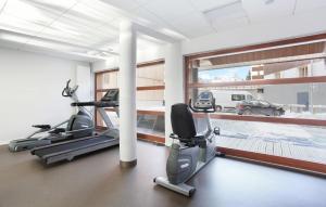 einen Fitnessraum mit zwei Laufbändern und einem großen Fenster in der Unterkunft Résidence Odalys Aquisana in La Salle Les Alpes