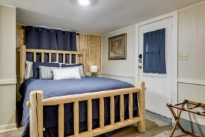 a bedroom with a wooden bed with a blue blanket at Spacious Lake Placid Retreat w/ Gorgeous Views! in Seguin
