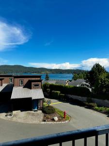 a view of a building with a fire hydrant and a lake at Race Rocks Townhouse - Pet Friendly Sooke Rental in Sooke