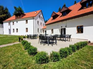 a courtyard of a white building with tables and chairs at Penzion Na bezu in Drahonice +71 photos