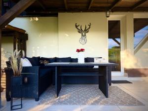 a table on a patio with a couch and a deer head on the wall at Bezdroża Mazurskie in Mrągowo