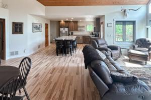 a living room with a leather couch and a kitchen at Aces and Eights Lodge in Sturgis