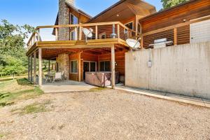 a large wooden house with a balcony and a patio at Aces and Eights Lodge in Sturgis
