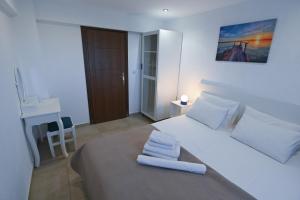 a bedroom with a large white bed with towels on it at Astri Villa in Ierissos