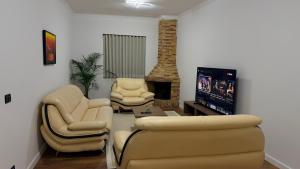 a living room with a couch and chairs and a tv at Solemar4 in Vlorë