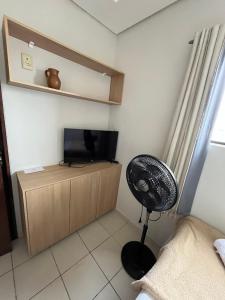 a room with a fan and a television in a room at Hotel Piracema in Caruaru +6 photos