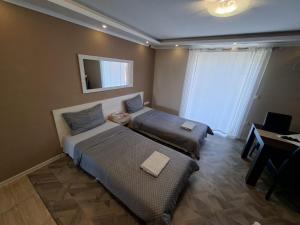 a hotel room with two beds and a desk and a desk at Apartman Bogić in Golubac